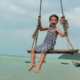 World-for-kids.com Kind auf Schaukel über dem Meer