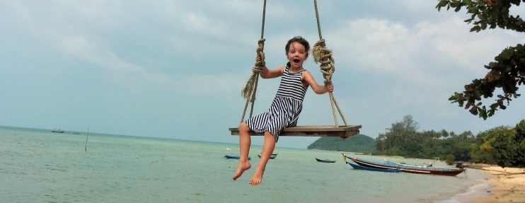 World-for-kids.com Kind auf Schaukel über dem Meer